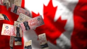 Canadian dollar banknotes, some appearing slightly damaged or burnt at the edges, are floating against a blurred background of the Canadian flag, symbolizing economic challenges.