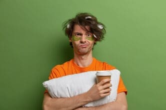 Close up on young man with a cup of coffee without being able to sleep