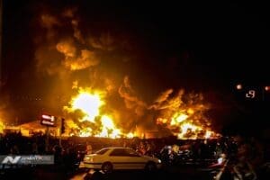 A photograph showing thick black smoke and flames rising from a damaged building in the aftermath of a reported Israeli attack on June 15, 2025.