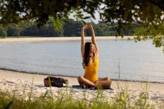 Full shot woman stretching and relaxing at the beach