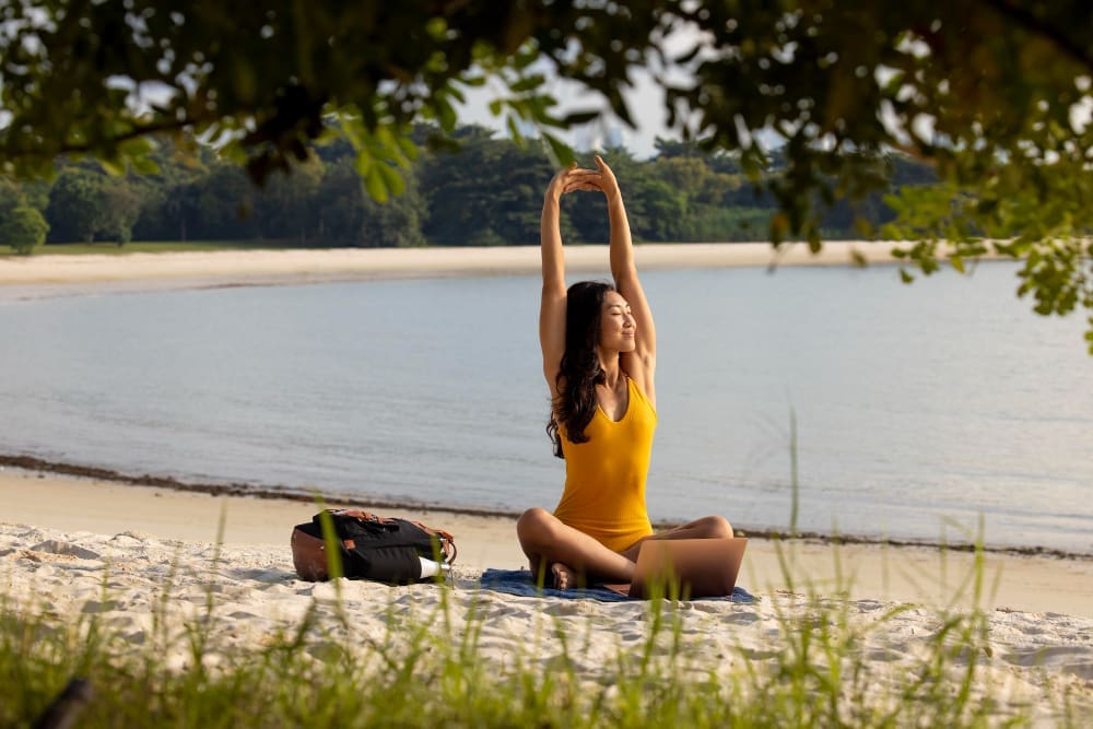 Full shot woman stretching and relaxing at the beach