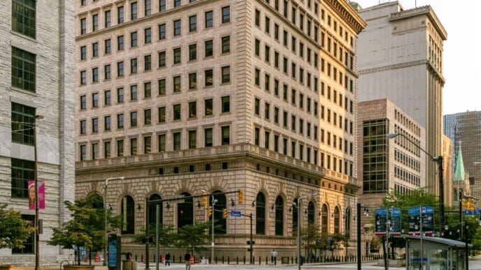 An oblique view of the historic Federal Reserve Bank of Cleveland, showcasing its grand neoclassical architecture, massive stone facade, and ornate details from a three-quarter angle.