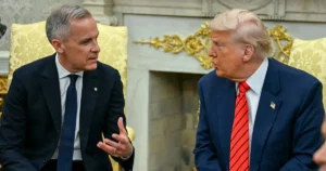 Mark Carney (left), wearing a dark suit and tie, is seated and gesturing while in discussion with U.S. President Donald Trump (right), who is also in a suit and red tie. They are in an ornate room.
