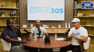 Three men are seated at a round wooden table with microphones in a modern studio, recording a show. A large screen in the background displays the logo for "MIAMI-DADE COUNTY STRIVE 305," and a "COMMUNITY NEWS NETWORK" logo is in the corner.