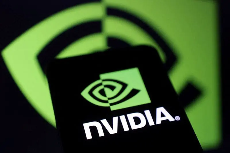 A smartphone displaying the bright green NVIDIA logo on its screen, held in front of a larger, blurred NVIDIA logo in the background, creating a repeated visual motif.