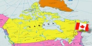 A colorful political map of Canada, highlighted in yellow, showing its provinces, territories, and major cities. A small 3D pin of the Canadian national flag is stuck into the map near the location of Ottawa.