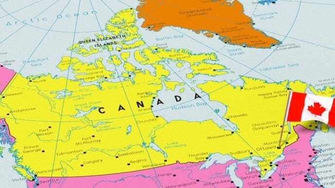 A colorful political map of Canada, highlighted in yellow, showing its provinces, territories, and major cities. A small 3D pin of the Canadian national flag is stuck into the map near the location of Ottawa.