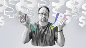 A worried man wearing glasses holds up a fan of long paper receipts in front of a background filled with large, faded dollar signs, symbolizing financial stress and economic concerns.