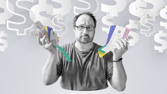A worried man wearing glasses holds up a fan of long paper receipts in front of a background filled with large, faded dollar signs, symbolizing financial stress and economic concerns.