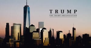 A silhouette of the Lower Manhattan skyline at dusk, featuring One World Trade Center, with a text overlay for "TRUMP" and "THE TRUMP ORGANIZATION" in the sky above.