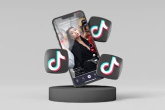 A smartphone displaying a social media app's video feed is shown floating above a dark cylindrical base, with three stylized musical note icons (TikTok logos) floating around it, all against a plain grey background.