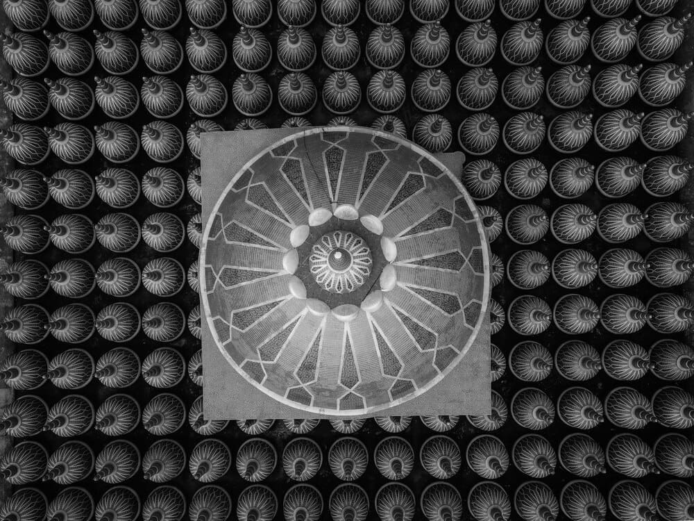 A large, white mosque with a domed roof stands in a courtyard.