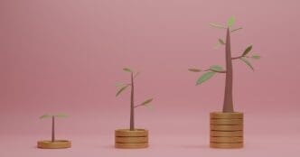 3D rendering of several stacks of coins with small trees growing on top, set against a pink backdrop.