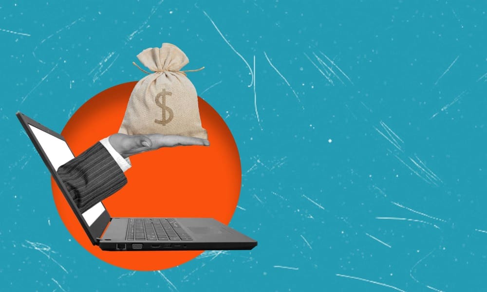 A hand in a suit sleeve emerging from a laptop screen, holding a money bag with a dollar sign, against a textured blue background with an orange circle.