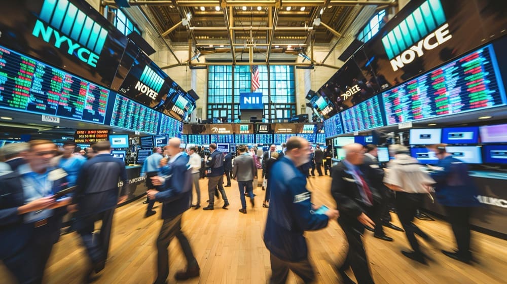 A bustling stock exchange trading floor with numerous traders, flashing digital displays, and an American flag.
