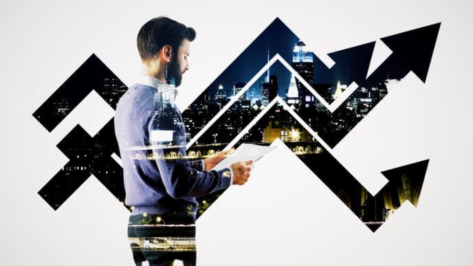A double exposure image of a man holding papers, superimposed with an upward-trending arrow and a cityscape at night, symbolizing financial growth.