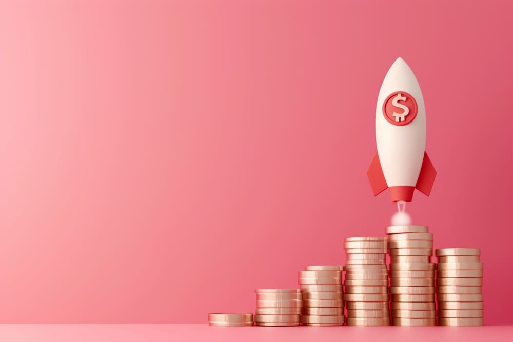 A 3D rendering of a white rocket with red fins and a dollar sign on its side, launching from a stack of golden coins, symbolizing rapid financial growth, all on a pink background.