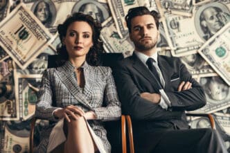 A powerful couple, a woman in a plaid blazer and a man in a dark suit, sit with confident expressions in front of a wall covered in US dollar bills, symbolizing immense wealth and power.