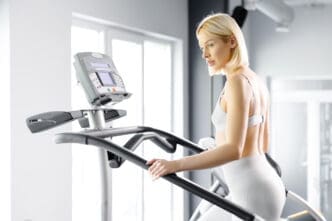 A young woman in sportswear working out on a stairway simulator at the gym.