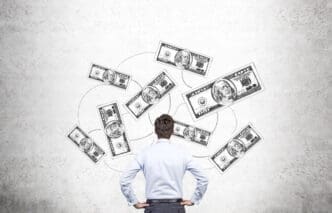 A man seen from behind, looking up at sketched dollar bills connected by lines on a concrete wall, symbolizing financial strategy.
