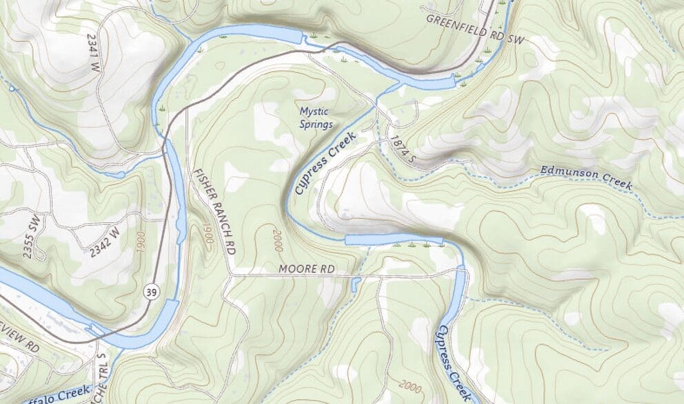 A topographic map showing a hilly, wooded area in Texas with a winding river (Cypress Creek), various roads, and elevation contours, highlighting the location of a summer camp area near Mystic Springs.