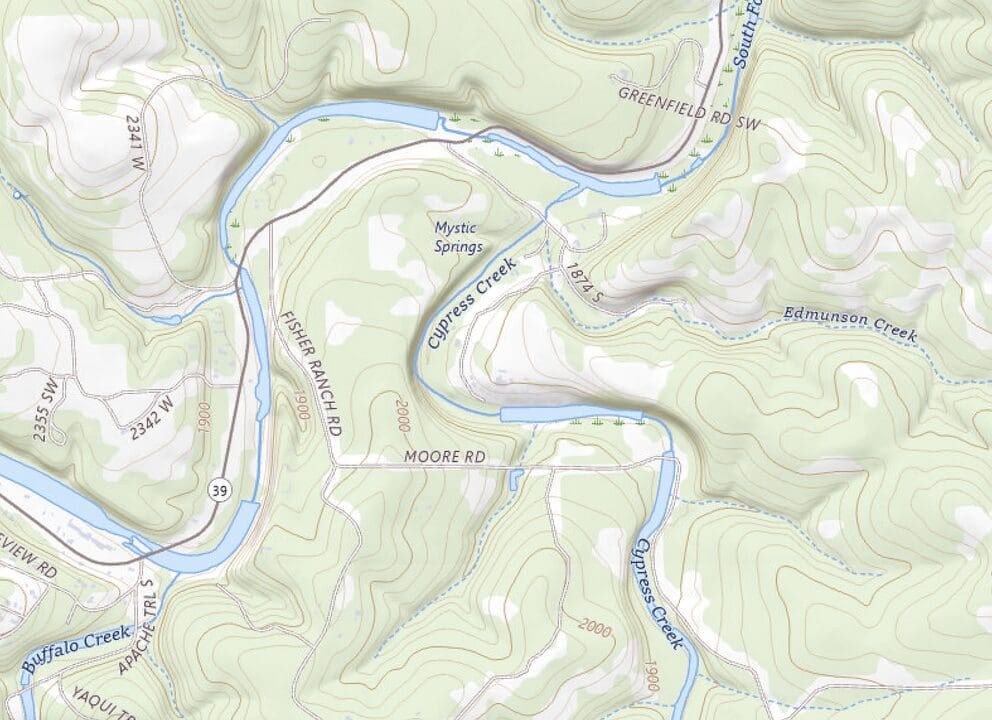 A topographic map showing a hilly, wooded area in Texas with a winding river (Cypress Creek), various roads, and elevation contours, highlighting the location of a summer camp area near Mystic Springs.