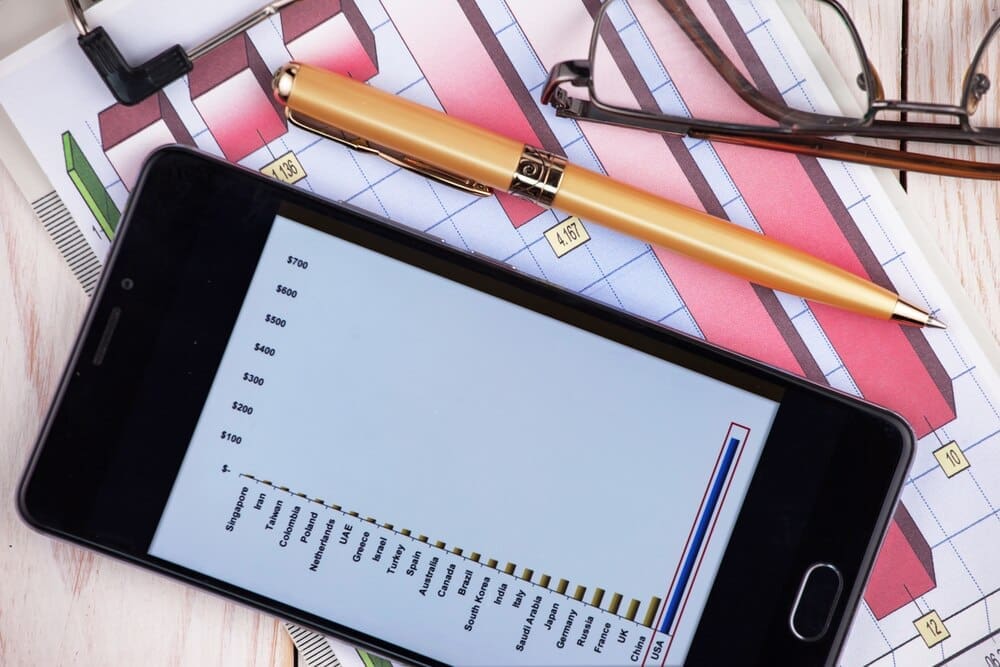 A collection of office supplies, including a laptop, notebook, and pen, are arranged on a table.