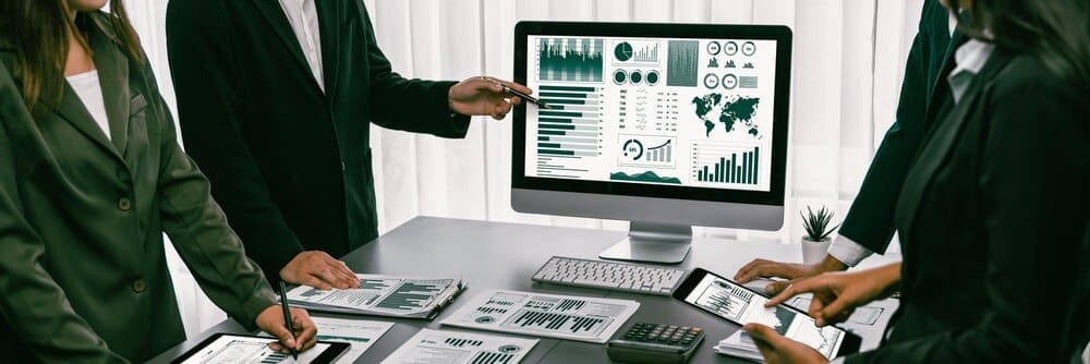 A team of financial analysts uses business intelligence fintech to analyze a financial report.