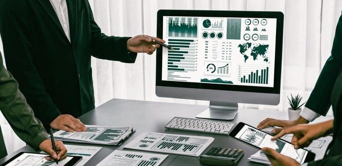 A team of analysts uses business intelligence fintech to analyze a financial report.