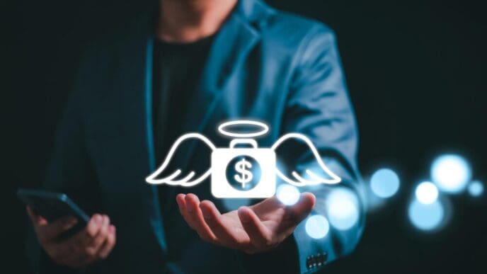 A businessman holds a money bag icon with wings, representing an angel investor concept.