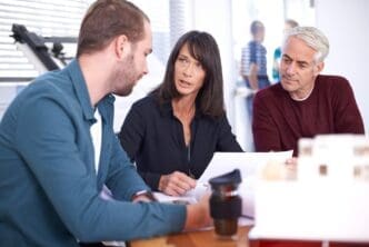 Business people and architects collaborate in a boardroom, planning construction projects.