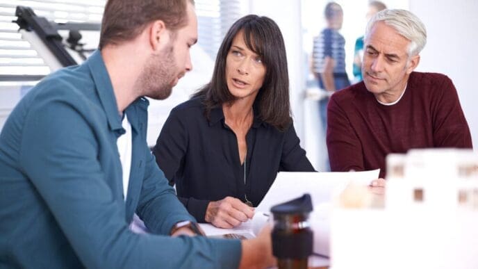 Business people and architects collaborate in a boardroom, planning construction projects.