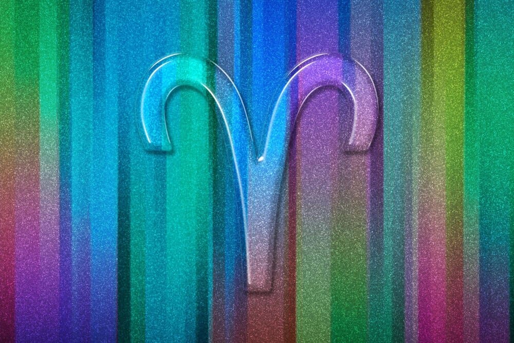 A colorful background features the Aries zodiac sign.