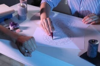 An astrologer shows a client their natal chart at a table, with a close-up view of the interaction.