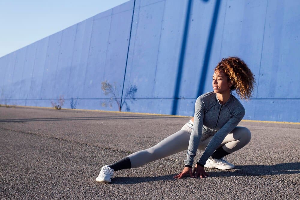 Athlete in athletic wear performing a side squat during a workout.