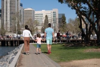 Back view of a smiling family walks down a city street, enjoying a casual day out.