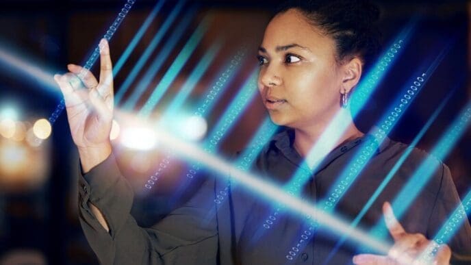 Black woman's hands interact with a glowing, futuristic digital interface in a dimly lit office setting.