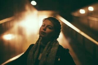 Blurred image of a woman walking at night, likely due to motion blur.