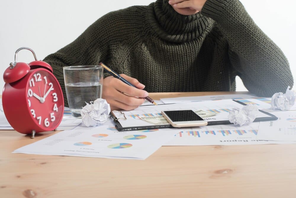 Close-up, top-down view of business people analyzing charts and graphs.