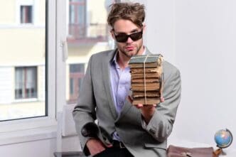 A businessman in sunglasses sits, likely outdoors, in a business composition.