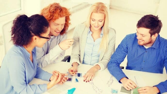 A diverse group of smiling people in a modern office setting collaboratively examines a sketch.