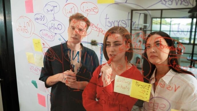 Business team members brainstorming ideas, using colorful sticky notes on a clean, white surface.