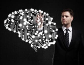 A businessman's finger presses a circuit board.