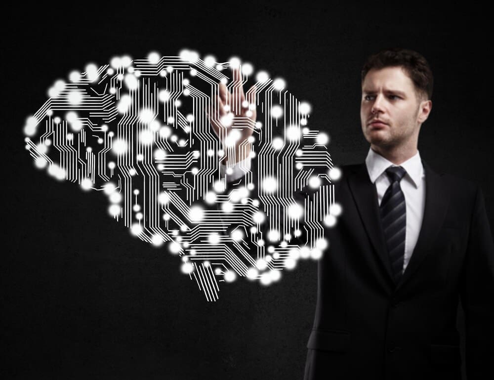 A businessman's finger presses a circuit board.