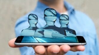 3D rendering of a businessman with a group of shiny glass avatar figures hovering above a smartphone.