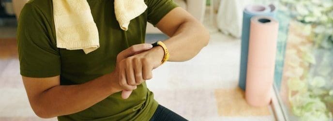 A person looks at a fitness tracker on their wrist after a workout.