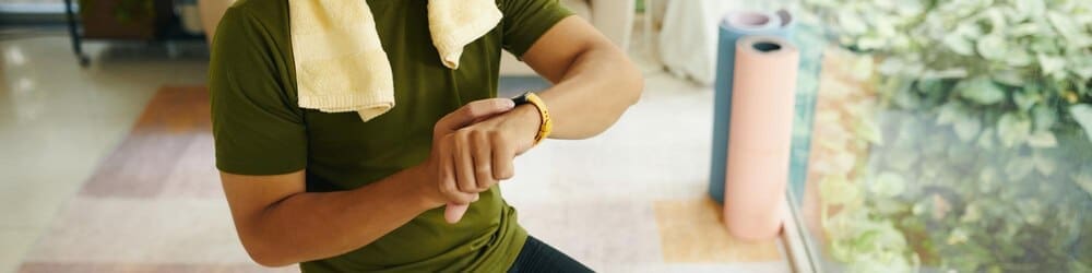A person looks at a fitness tracker on their wrist after a workout.