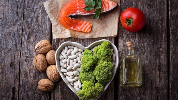 A close-up shot showcases a variety of heart-healthy foods, such as fruits and vegetables, arranged to emphasize a diet focused on lowering cholesterol.