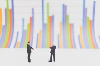 Close-up view shows small figurines arranged in front of a bar graph on a table.
