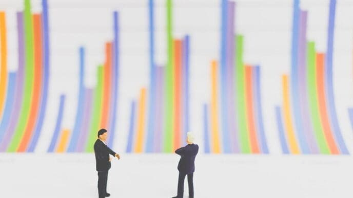 Close-up view shows small figurines arranged in front of a bar graph on a table.